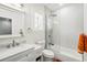 Bright bathroom with glass enclosed shower and tub, modern vanity, and stylish fixtures and shuttered window at 1239 Roycroft Ave, Kissimmee, FL 34747