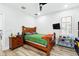 Comfortable bedroom with hardwood floors, a ceiling fan, a large window and a wooden bed frame at 1239 Roycroft Ave, Kissimmee, FL 34747