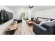 This bonus room includes hardwood floors, a grey sectional, and space for activities at 1239 Roycroft Ave, Kissimmee, FL 34747