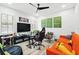 A well-lit bonus room includes tv, game chair, sofa and football artwork at 1239 Roycroft Ave, Kissimmee, FL 34747
