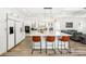 Contemporary kitchen boasts island with seating, white cabinetry, and stainless steel appliances at 1239 Roycroft Ave, Kissimmee, FL 34747