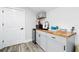 Charming kitchenette featuring gray cabinets, butcher block countertop, and a mini-fridge near a paneled door at 1239 Roycroft Ave, Kissimmee, FL 34747