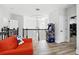 A cozy upstairs landing area includes an arcade game, orange seating and hardwood floors at 1239 Roycroft Ave, Kissimmee, FL 34747