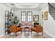 Inviting living room with cozy seating, decorative shelving, and an elegant staircase at 1239 Roycroft Ave, Kissimmee, FL 34747