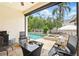 Inviting outdoor patio with comfortable seating, a grill, and a view of the sparkling pool and spa at 1239 Roycroft Ave, Kissimmee, FL 34747