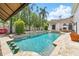 Beautiful swimming pool with stone waterfall feature, built-in bar stools, and lounging areas at 1239 Roycroft Ave, Kissimmee, FL 34747