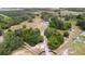Aerial view of white house with gray roof and long driveway on expansive land with dense trees at 24025 Ranch Rd, Astatula, FL 34705