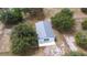 Aerial view of barn, surrounded by trees, on a grassy property with fencing at 24025 Ranch Rd, Astatula, FL 34705