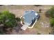 Aerial view of a two-story home with a gray shingled roof, side entry garage, and a screened pool at 24025 Ranch Rd, Astatula, FL 34705