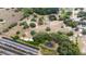Aerial shot of a property featuring a house, pond, and rows of planted trees at 24025 Ranch Rd, Astatula, FL 34705