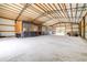 Well-lit barn interior featuring horse stalls, open space, and a durable concrete floor for versatile use at 24025 Ranch Rd, Astatula, FL 34705