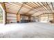 Spacious barn interior with horse stalls, metal roof, concrete floor, and ample room for equipment and activities at 24025 Ranch Rd, Astatula, FL 34705