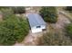Aerial view of a metal barn with a gray roof, white trim, and a large open bay on a rural lot at 24025 Ranch Rd, Astatula, FL 34705