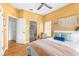 Bright bedroom features warm yellow walls, a ceiling fan, and herringbone wood floors at 24025 Ranch Rd, Astatula, FL 34705