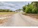Gravel driveway approach to the home on a large lot surrounded by trees at 24025 Ranch Rd, Astatula, FL 34705