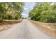 Gravel driveway leading up to the white house surrounded by trees at 24025 Ranch Rd, Astatula, FL 34705
