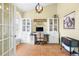 Well-lit home office with modern cabinets, neutral decor, and stylish herringbone floors at 24025 Ranch Rd, Astatula, FL 34705
