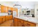 Bright kitchen featuring granite counters, wooden cabinets, stainless appliances, and an open view to the living area at 24025 Ranch Rd, Astatula, FL 34705