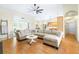 Open concept living room with wood floors, a large sectional, and views of the kitchen at 24025 Ranch Rd, Astatula, FL 34705