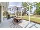Outdoor dining on the screened patio with table, chairs and striped umbrella at 24025 Ranch Rd, Astatula, FL 34705