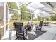 Screened patio boasts rocking chairs, fire pit, and outdoor dining under an umbrella at 24025 Ranch Rd, Astatula, FL 34705