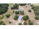 Aerial view of a home and barn on a large lot, lush trees, green grass, and blue skies at 24025 Ranch Rd, Astatula, FL 34705