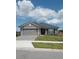 Charming single-story home with manicured lawn, gray siding, and tiled roof under a beautiful sky at 4616 Grandview Glen Dr, Auburndale, FL 33823