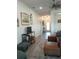Spacious living room with wood-look tile flooring, leather furniture, TV, and access to the foyer at 4616 Grandview Glen Dr, Auburndale, FL 33823