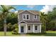 Charming two-story home with gray siding, white trim, a welcoming porch, and lush landscaping at 606 Terrapin Dr, Debary, FL 32713
