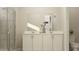 Well-lit bathroom with double sinks, large mirrors, white cabinetry, and gray shower at 7244 Summer Ivy Aly, Orlando, FL 32829