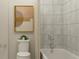 Cozy bathroom featuring neutral tile, shower-tub, wall art, and toilet with a small potted plant at 7244 Summer Ivy Aly, Orlando, FL 32829