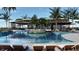Large community pool with lush landscaping, lounge chairs, and tropical foliage, and a modern clubhouse at 7244 Summer Ivy Aly, Orlando, FL 32829