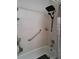 Functional bathtub with a shower, safety bar, and white tile, creating a bright bathroom space at 242 Rosa Blanca, Winter Haven, FL 33884