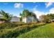 Backyard of a home with an overgrown lawn and a commercial building next door at 117 Sw 3Rd Ave, Mulberry, FL 33860