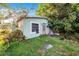 Exterior shot of a light green, one-story home with debris in the yard and overgrown foliage at 117 Sw 3Rd Ave, Mulberry, FL 33860
