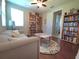 Cozy bedroom or office with hardwood floors, a comfortable couch, and bookshelves filled with books at 13525 Gorgona Isle Dr, Windermere, FL 34786