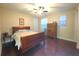 Cozy bedroom with a wooden sleigh bed, a window for natural light, and hardwood flooring at 13525 Gorgona Isle Dr, Windermere, FL 34786