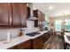 Modern kitchen with stainless steel range hood, dark wood cabinets and white quartz countertops at 13525 Gorgona Isle Dr, Windermere, FL 34786