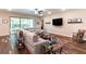 Comfortable living area with a large sectional sofa, big screen television, and sliding glass doors at 13525 Gorgona Isle Dr, Windermere, FL 34786