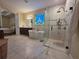 Bright bathroom with freestanding tub, walk-in shower, and stained-glass window, seamlessly connects to main bedroom at 13525 Gorgona Isle Dr, Windermere, FL 34786