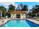 Community pool with plenty of seating for residents and guests, surrounded by mature trees at 13525 Gorgona Isle Dr, Windermere, FL 34786