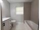 Bright bathroom featuring a white vanity, toilet, and bathtub with tiled surround at 1505 Piedmont Dr, Deltona, FL 32725