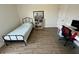 Bedroom with light walls, wood-look floors, basic black metal bed frame, and desk at 11578 Ashlin Park Blvd, Windermere, FL 34786