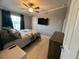 Comfortable bedroom with wood-look tile flooring, ceiling fan, and a mounted flat-screen TV at 118 Jana Cir, Auburndale, FL 33823