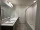 Well-lit bathroom featuring a sleek vanity, a large mirror, and a shower-tub combination at 1351 Pompay Dr, Davenport, FL 33896