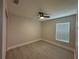 This bedroom has a ceiling fan, light gray walls and a window at 1351 Pompay Dr, Davenport, FL 33896