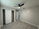 Simple bedroom with a ceiling fan, spacious closet, and neutral decor at 1351 Pompay Dr, Davenport, FL 33896
