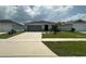 Inviting single-story home featuring a two-car garage and a neatly landscaped front yard at 1351 Pompay Dr, Davenport, FL 33896