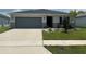 Charming single-story home with a well-manicured lawn, two-car garage, and a welcoming entrance at 1351 Pompay Dr, Davenport, FL 33896