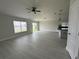 Spacious open-concept living room featuring plenty of natural light and an adjacent modern kitchen at 1351 Pompay Dr, Davenport, FL 33896